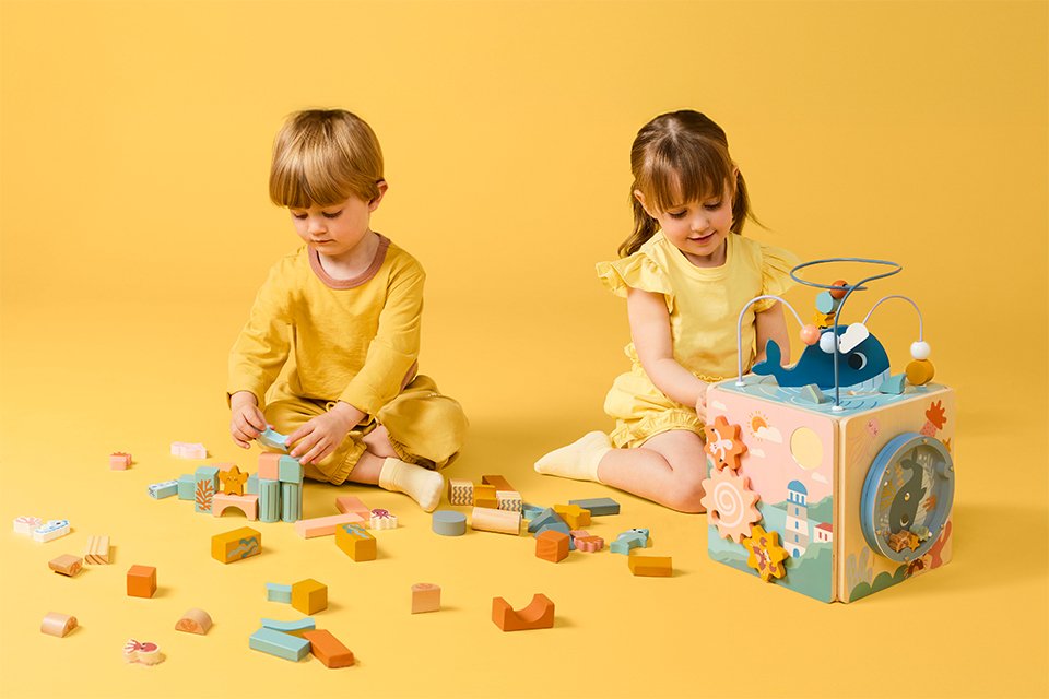 Two toddlers playing with Chad Valley's wooden toys.